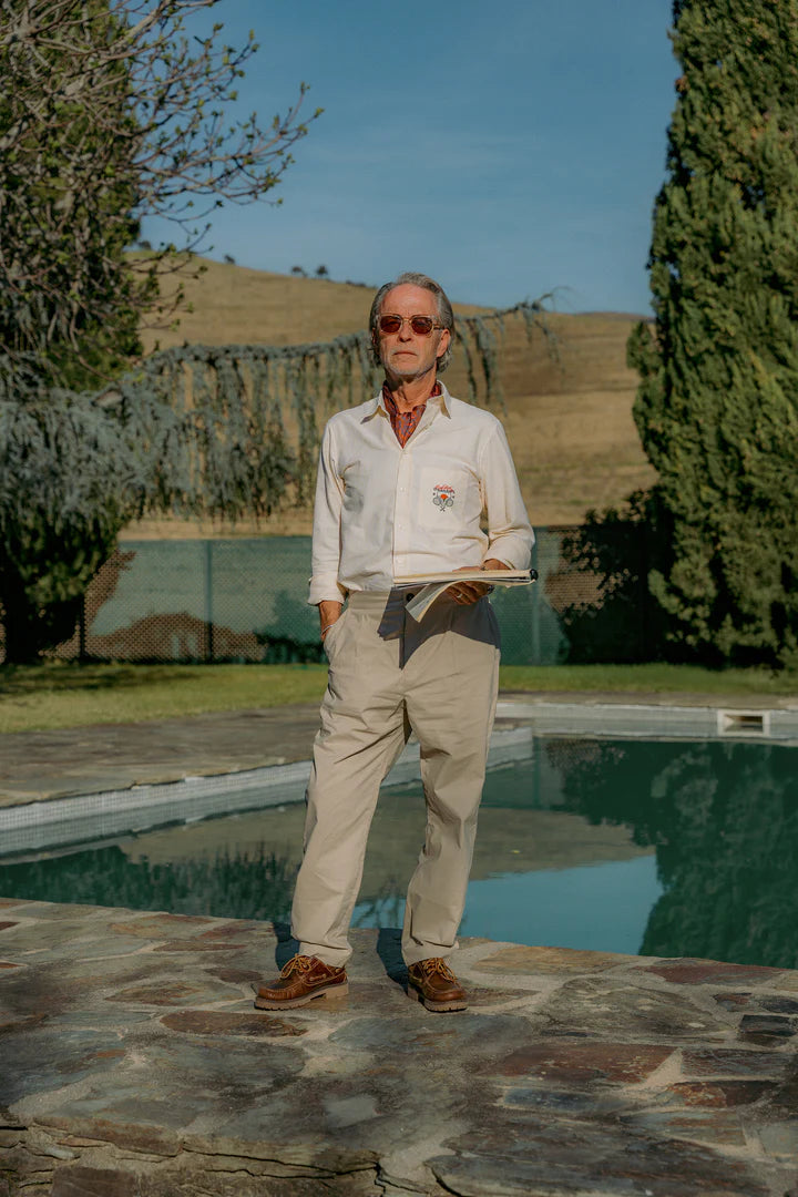 Man standing by a pool with a scenic background